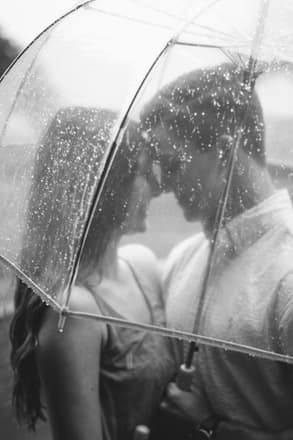 A kiss under a clear umbrella in the rain